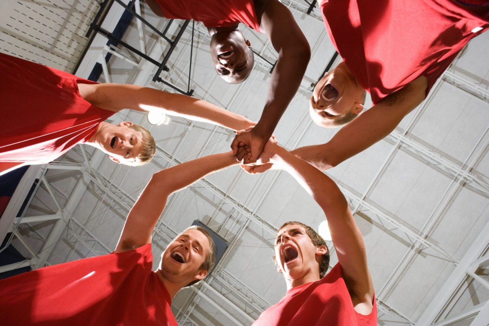 A group of people holding hands in the middle of a circle.